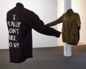 Deborah Rundle, Political Colours, 2018 (install view). Black shirt with printed text, military patch and officers’ stars, khaki jacket with printed text, mannequin torsi. Commissioned by Te Tuhi. Photo by Sam Hartnett.