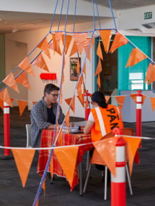 PĀNiA!, Pakuranga Customs House/Attitude Arrival Lounge, 2019 (install view). Rope, bunting, concrete temporary fence feet, furniture, bollards, tables, chairs, blanket, passports, stamps, inkpads, stationery, fixings. Courtesy the artist, Te Tuhi and Mokopōpaki, Auckland. Photo by Sam Hartnett.