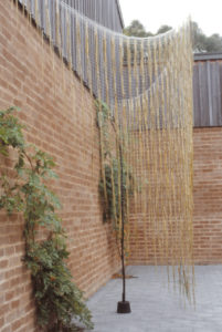 Maureen Lander, Talking to a Brick Wall, 1988 (installation view). Harakeke (New Zealand flax), nylon netting, concrete, korari (flax flower stalks). Collection of the artist.