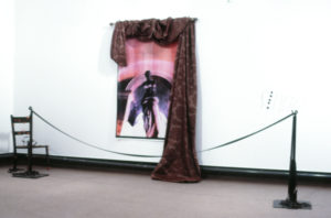Deborah Smith, Singe, 1991 (installation view). Laser prints, curtain, stanchions, chair, candles.
