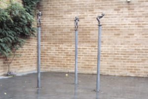 Richard McWhannell, Hear No, See No, Speak No, 1987 (installation view). Bronze and galvanized pipe.